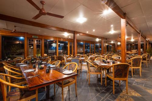 an empty restaurant with wooden tables and chairs at Knysna Log-Inn Hotel in Knysna