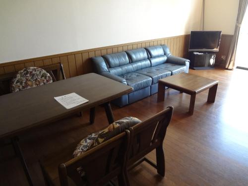 a living room with a couch and a table at Farm Inn Minamiboso in Minamiboso
