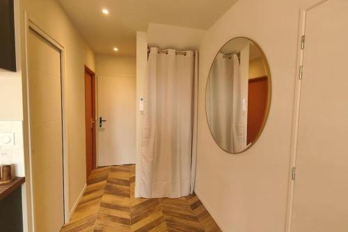 bagno con specchio e tenda per la doccia di Appartement Jasmin Jacuzzi Piscine a Lacanau