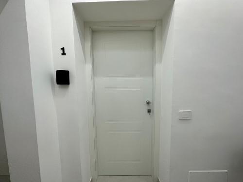 a white door with the number one on the wall at Hary Home in Brindisi