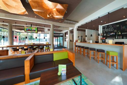 a restaurant with a bar with tables and chairs at 7THINGS - my basic hotel in Bremen