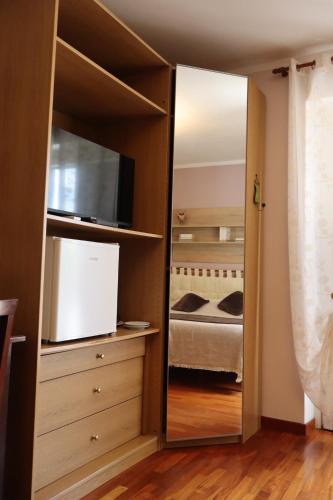 a mirror in a bedroom with a bed and a television at Guest House La Palazzina in Rieti