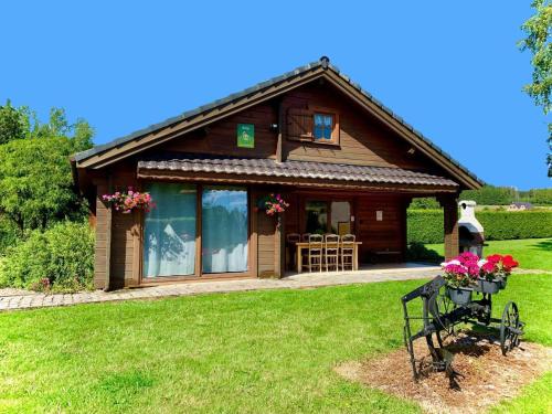 a small wooden house with flowers in a yard at Le gite du gabelou in Hargnies