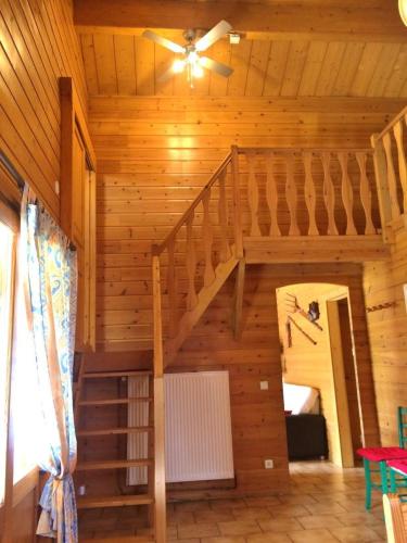 a staircase in a wooden room with a ceiling fan at Le gite du gabelou in Hargnies