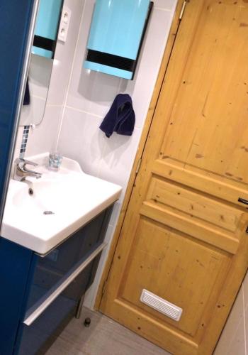 a bathroom with a sink and a wooden door at Le gite du gabelou in Hargnies