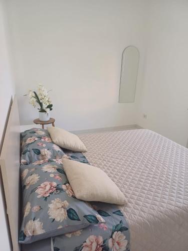 una camera da letto con un letto decorato con fiori di "Nonna Maria" a Venegono Superiore