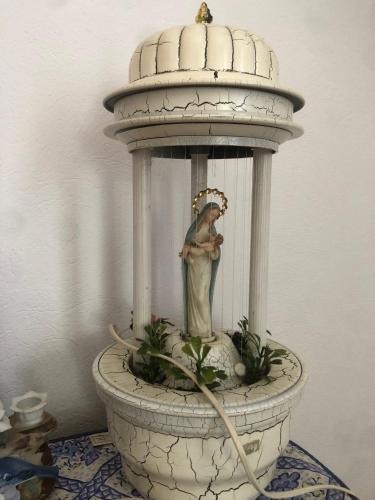 a statue of a woman in a bird bath at Casa Verde in Vaţa de Jos