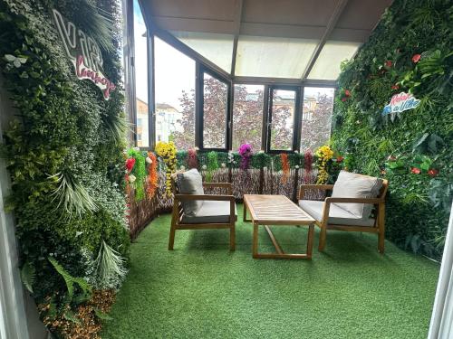 a room with two chairs and a table and flowers at Très beau logement chic & cosy in Bonneuil-sur-Marne