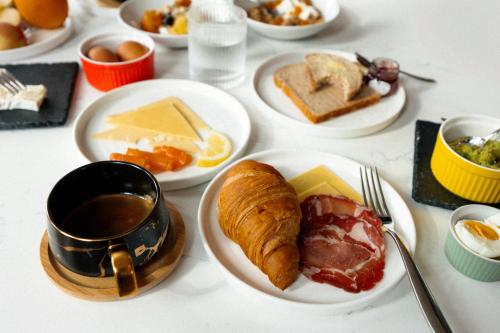 a table with plates of breakfast foods and a cup of coffee at The Gate London City in London