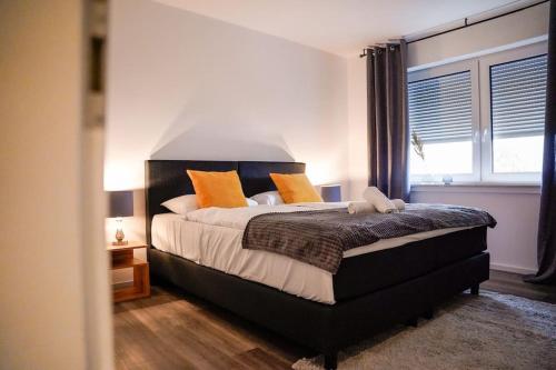 パーダーボルンにあるYellow Stationのオレンジ色の枕が付いた大きなベッドのある寝室