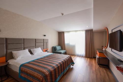 a hotel room with a bed and a flat screen tv at İncipark Hotel in Sakarya