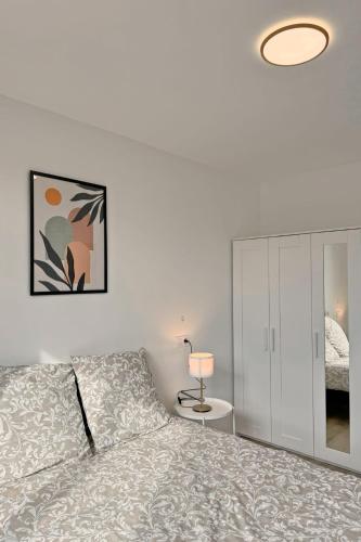 a bedroom with a bed and a cabinet and a lamp at Cozy Paris Gateway Apartments Groups with free parking in Vitry-sur-Seine
