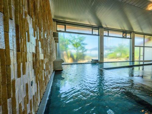 a swimming pool in a building with a large window at KAMENOI HOTEL Nachi Katsuura Kumano Kodo in Nachikatsuura