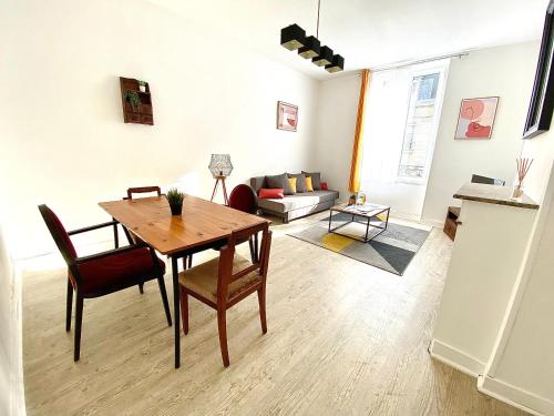 un salon avec une table, des chaises et un canapé dans l'établissement Le Marceau, spacieux et chaleureux, à Limoges