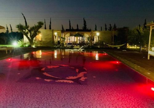 a pool with red lights in front of a building at VILLA GIULIA & SOLEY in Douar Sidi Ayad