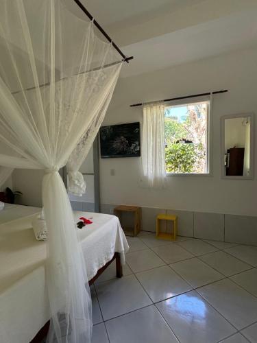 a bedroom with a bed with a mosquito net at Pousada Horizonte Azul in Ilha de Boipeba