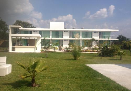 a large white house with a lawn in front of it at Quinta Souffle in Xochitepec