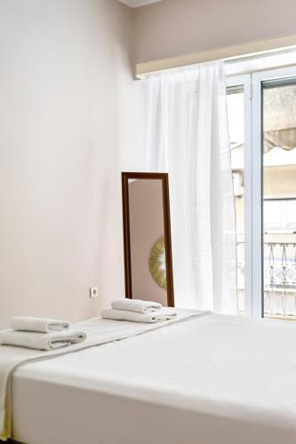 a white bedroom with a mirror on a bed at GK Niki by GK Properties in Athens
