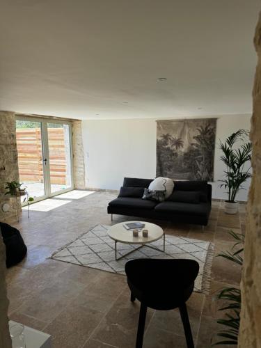 un salon avec un canapé noir et une table dans l'établissement La Grange d Ulysse, à Crayssac
