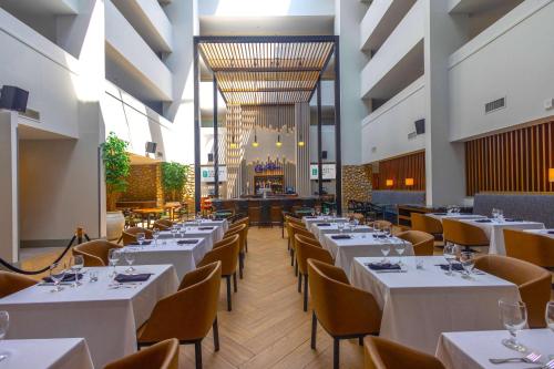 a dining room with white tables and chairs at Embassy Suites by Hilton Philadelphia Valley Forge in Wayne