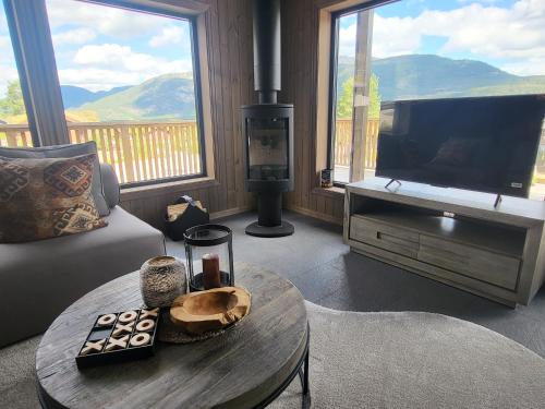 a living room with a tv and a coffee table at Elegant black chalet with top amenities in Vrådal in Vradal