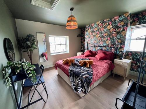 a bedroom with a bed with a red bedspread at Stylish Flat With Stunning Views in Worcester