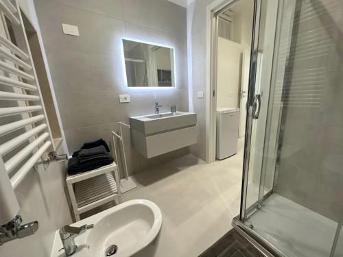 a white bathroom with a sink and a shower at Hary Home in Brindisi