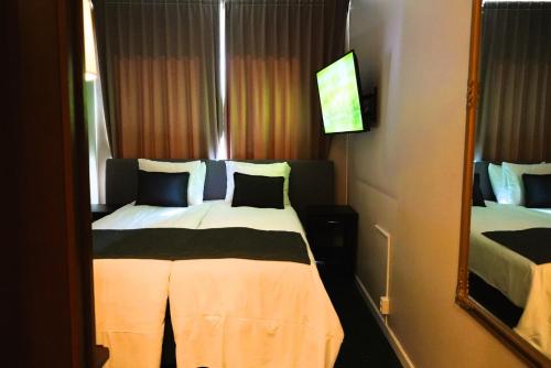 Una cama o camas en una habitación de Vänerport Stadshotell i Mariestad