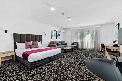 a hotel room with a bed and a living room at Quality Hotel Parklake Shepparton in Shepparton