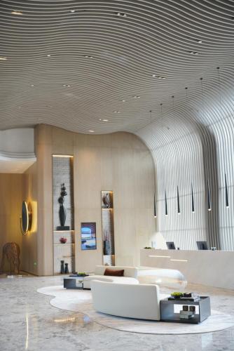 a lobby with white furniture in a building at New Century Mansion Resort Hangzhou Xianghu Baoyi in Xiaoshan