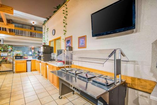 a kitchen with a counter with a flat screen tv on the wall at Clarion Inn Grand Junction Airport in Grand Junction