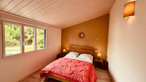 a bedroom with a red bed and two windows at Maison d'architecte de la Parée in Saint-Jean-de-Monts