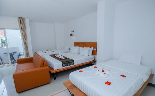 a bedroom with two beds and a couch at Bliss & Beats Hostel in Phnom Penh
