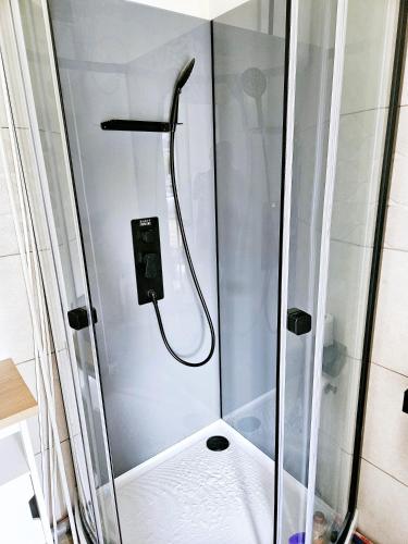 une douche avec une porte vitrée dans une salle de bain dans l'établissement L'Echappée, à Saint-Jean-dʼIllac