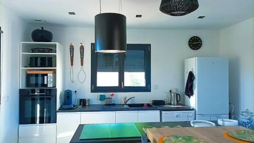 a kitchen with a sink and a refrigerator at Villa Belles étoiles en Cévennes classée 3 étoiles avec piscine privée dans le Gard in Ribaute-les-Tavernes