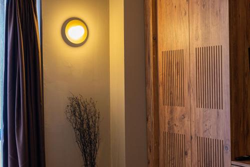 a clock on a wall next to a vase with a plant at Tare Houses in Istanbul