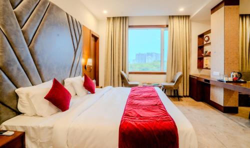a hotel room with a large bed with red pillows at Hotel Amantran Inn - City Centre in Udaipur