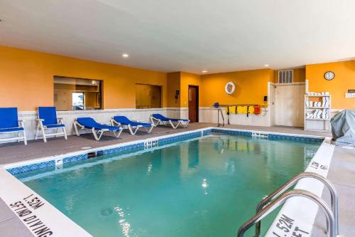 a swimming pool with blue chairs in a hotel at Comfort Suites Fort Wayne - Dupont in Fort Wayne