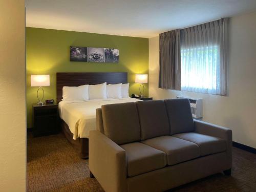 a hotel room with a bed and a couch at Suburban Studios Melbourne Airport in Melbourne