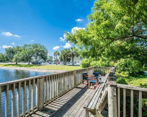 a wooden deck with chairs and a table on the water at Suburban Studios Melbourne Airport in Melbourne