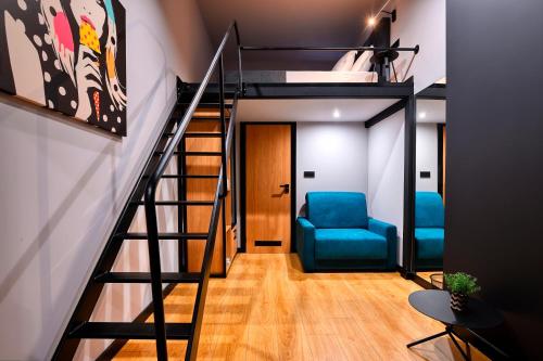a room with a loft bed and a blue chair at Smart Rooms in Varna City