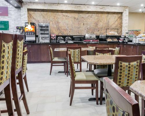 a restaurant with tables and chairs and a counter at Comfort Inn Metro Airport in Romulus