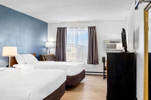 a hotel room with two beds and a television at Econo Lodge Billings in Billings