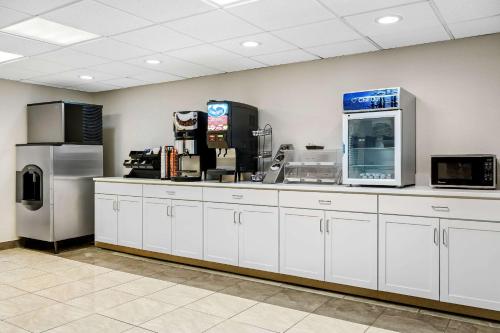 ビリングスにあるEcono Lodge Billingsの白いキャビネットと冷蔵庫付きの広いキッチン