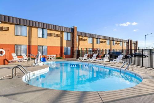 a swimming pool with chairs and a building at Econo Lodge Billings in Billings