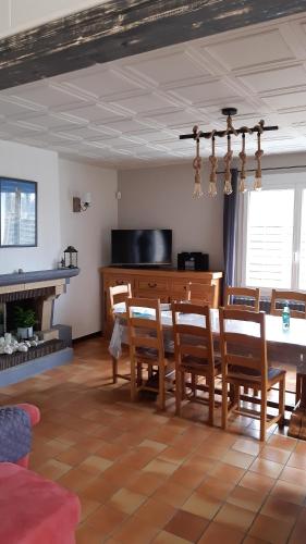 un salon avec une table et des chaises et une cheminée dans l'établissement Route de l'océan/Maison 8 pers/entrée FOURAS, à Saint-Laurent-de-la-Prée