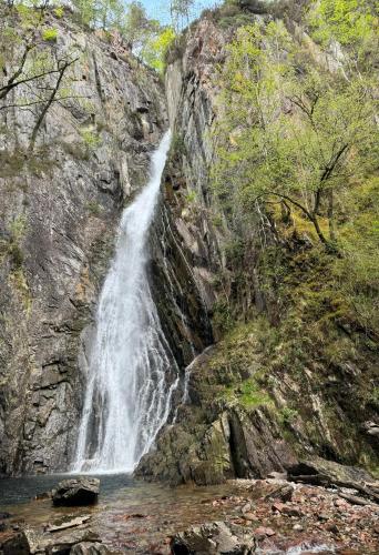 a waterfall on the side of a rocky mountain at The Steadings in Kinlochleven