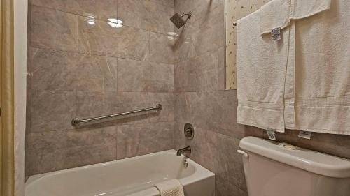 a bathroom with a tub and a toilet and a sink at Quality Inn Ennis in Ennis