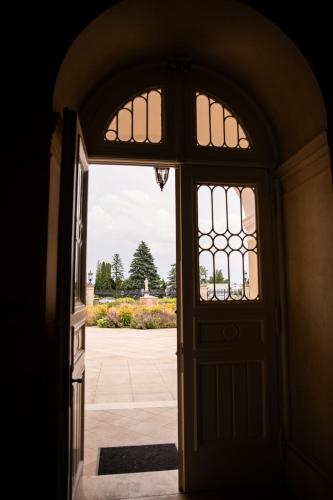 an open door leading to a courtyard with flowers at GOYA Vitality Hotel in Voderady