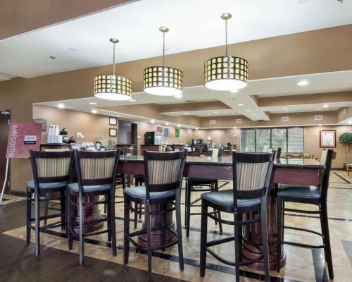 a bar in a restaurant with chairs and lights at Comfort Suites Topeka Northwest in Topeka